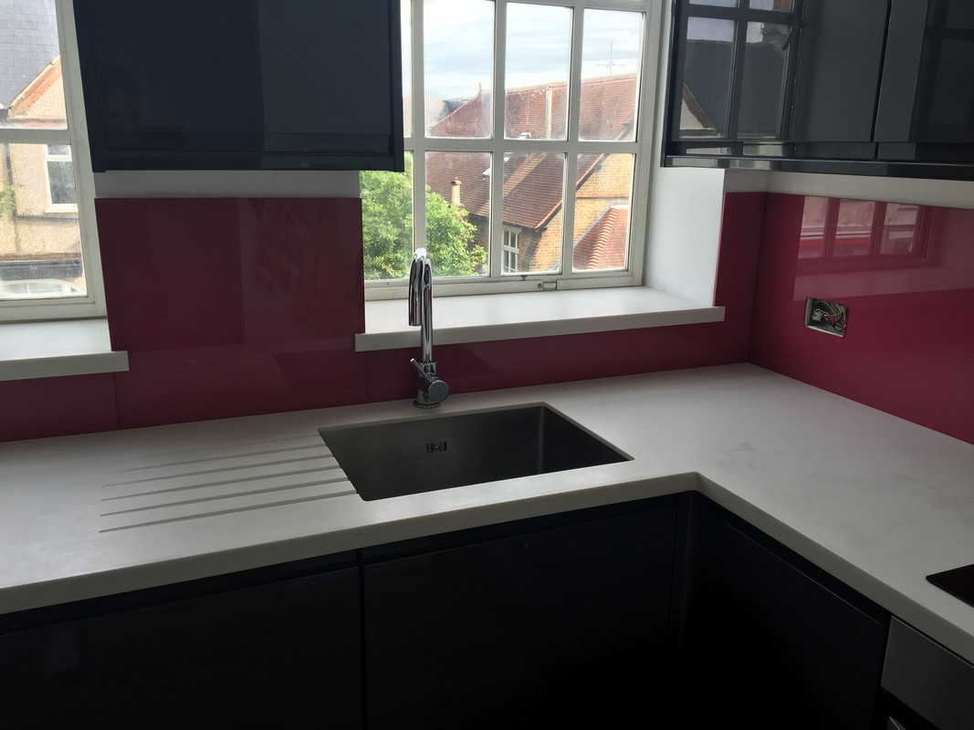 Deep plum coloured glass splashback in modern Canning Town kitchen